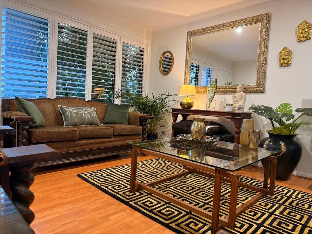 米兰达Miranda Stylish 2 Bed near Cronulla & Airport的客厅里有一张沙发和一张桌子。