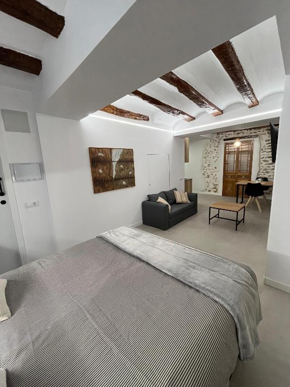 a bedroom with a large bed and a couch at Les Cases de Laia in Bocairent
