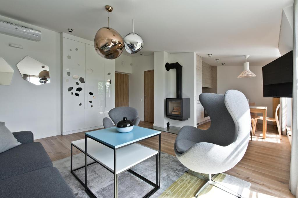 ein Wohnzimmer mit einem Sofa, einem Tisch und Stühlen in der Unterkunft Aura apartamentai in Druskininkai