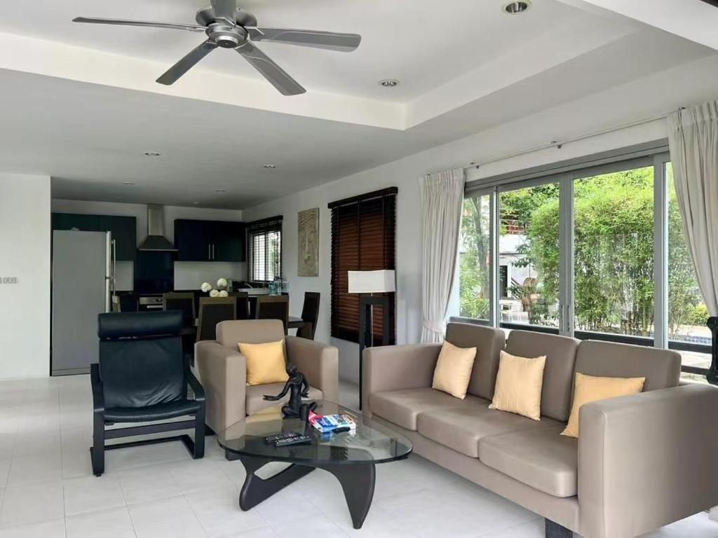 a living room with a couch and a table at Villa 3 Tropical Oasis with Private Pool in Plai Laem