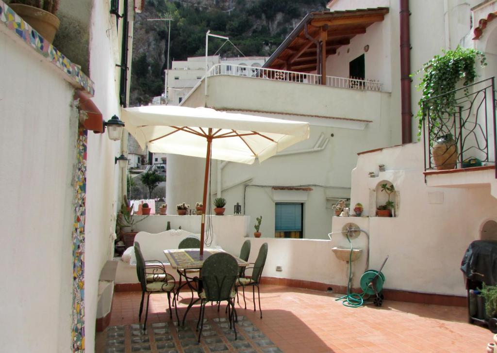 une terrasse avec une table, des chaises et un parasol dans l'établissement Flora, à Atrani