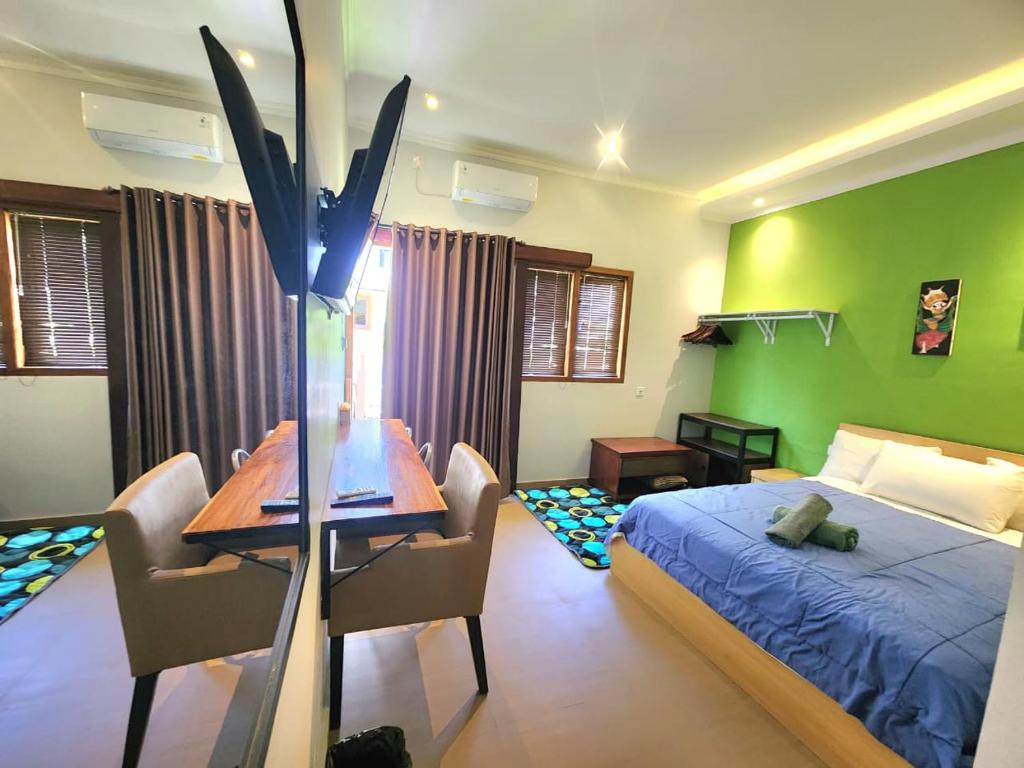 a bedroom with a bed and a table and chairs at Nana's Villa Sanur in Sanur