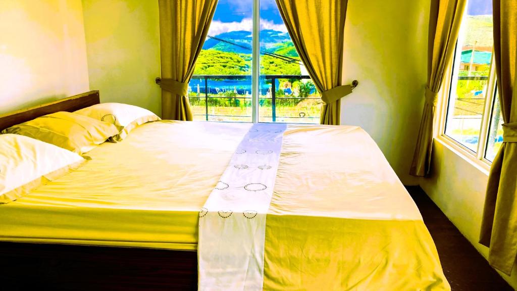 a bed in a room with a large window at Lotus View Home in Nuwara Eliya