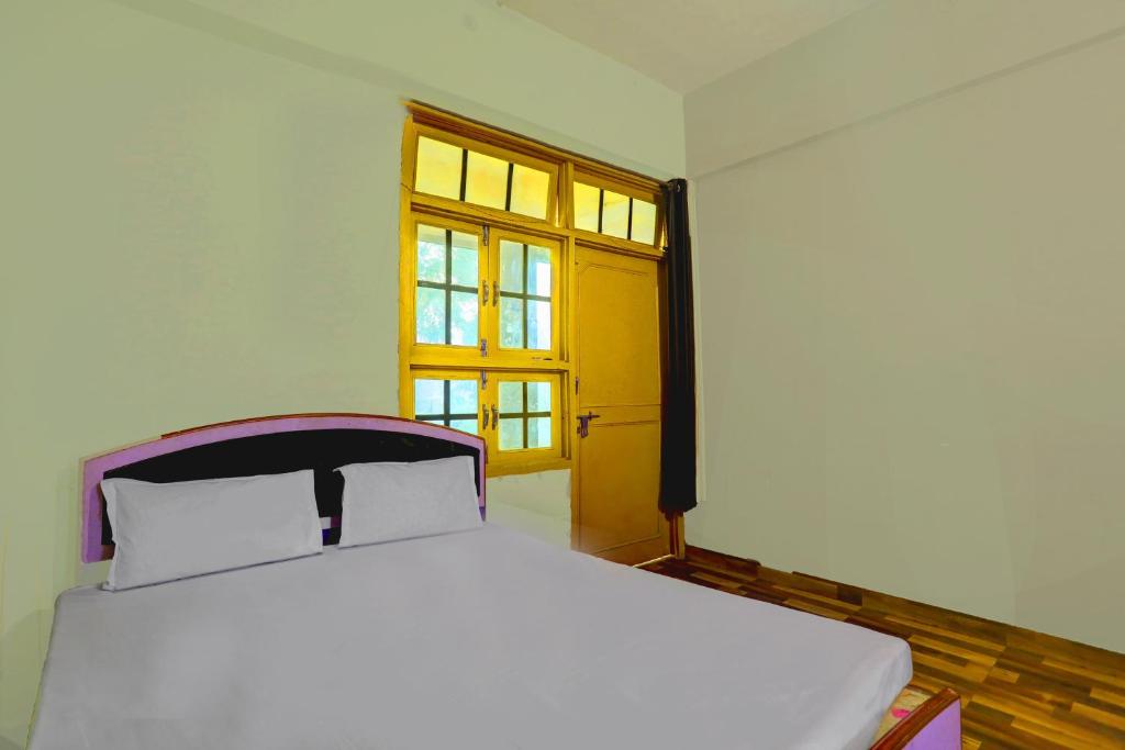 Una cama blanca en una habitación con ventana. en HOTEL O SK GRAND, en Sitāpur