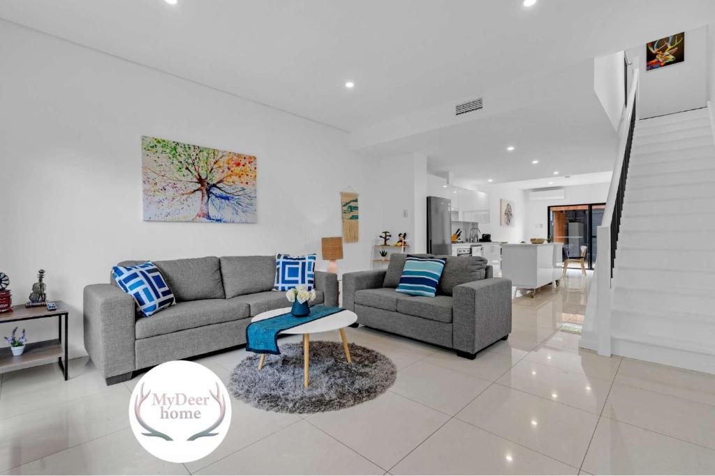 un salon avec deux canapés et une table dans l'établissement 2BR Townhouse CBD Chinatown Free WiFi FreeParking, à Adélaïde