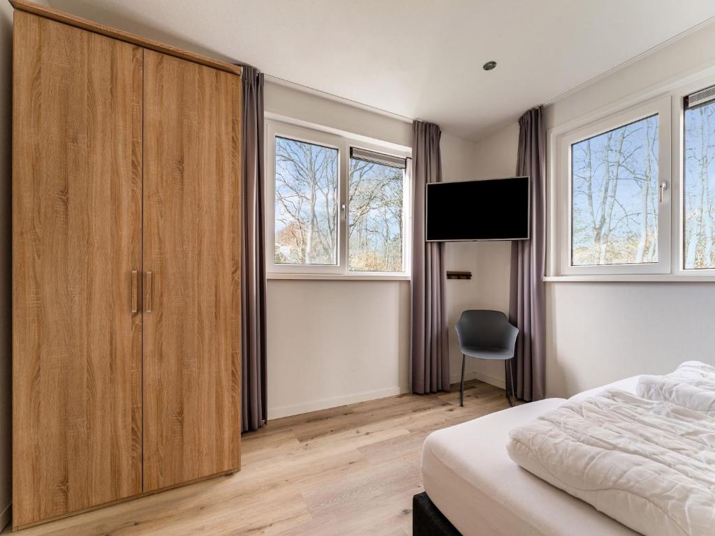 - une chambre avec une grande armoire en bois et un lit dans l'établissement Serene Holiday Home in De Koog Texel with Sauna, à Westermient