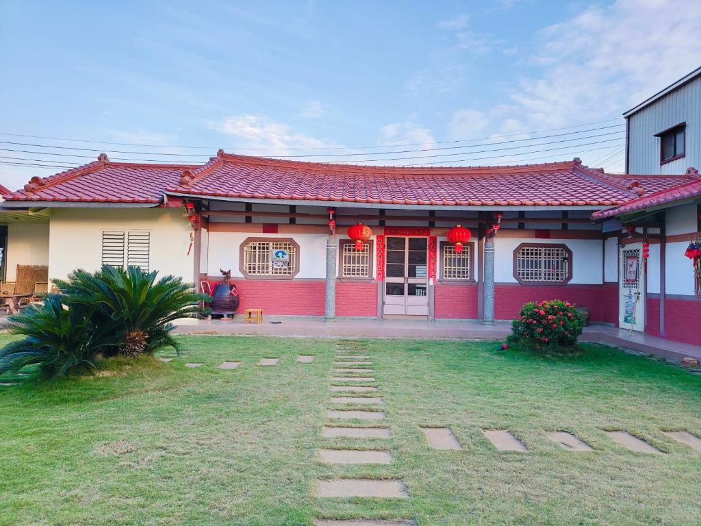 ein rot-weißes Haus mit einer Person davor in der Unterkunft J ancient house in Lucao