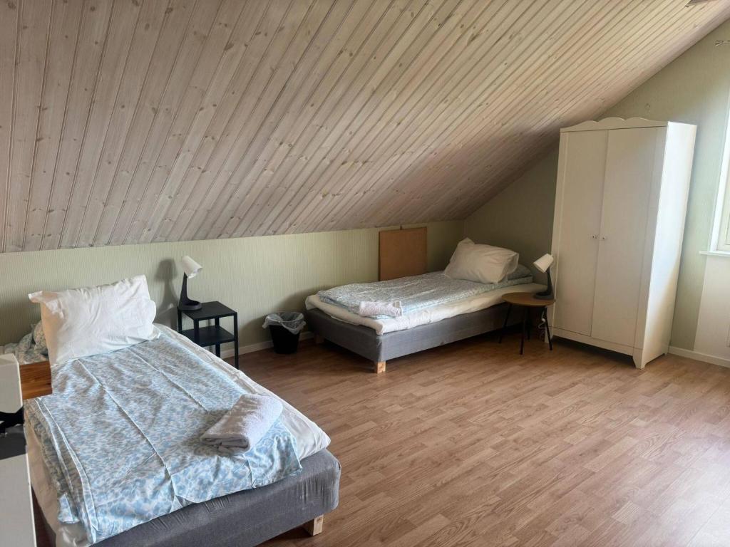 ein Schlafzimmer mit zwei Betten und einer Holzdecke in der Unterkunft Family & Worker Accommodations in Göteborg in Olofstorp