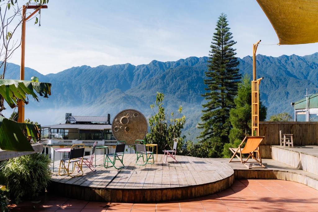 萨帕D Home Sapa 8的庭院配有椅子和桌子,后面是山脉