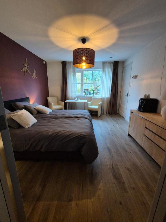 ein Hotelzimmer mit einem großen Bett und einem großen Fenster in der Unterkunft Villa Bergstein in Tuk