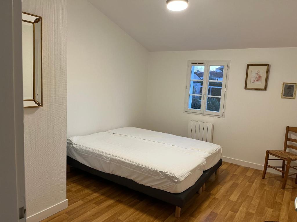 une petite chambre avec un lit et une fenêtre dans l'établissement Villa les Mésanges 5 min from the beaches, à Vaux-sur-Mer