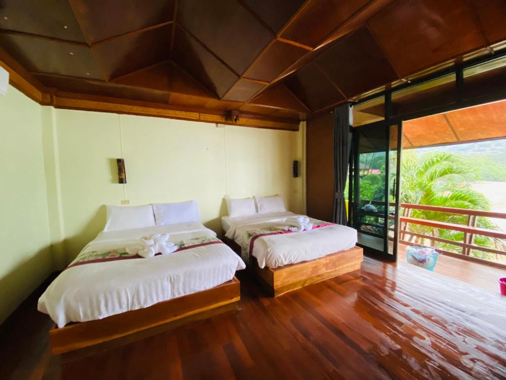 une chambre avec deux lits et une grande fenêtre dans l'établissement Family view A2, à Ko Bu Bu