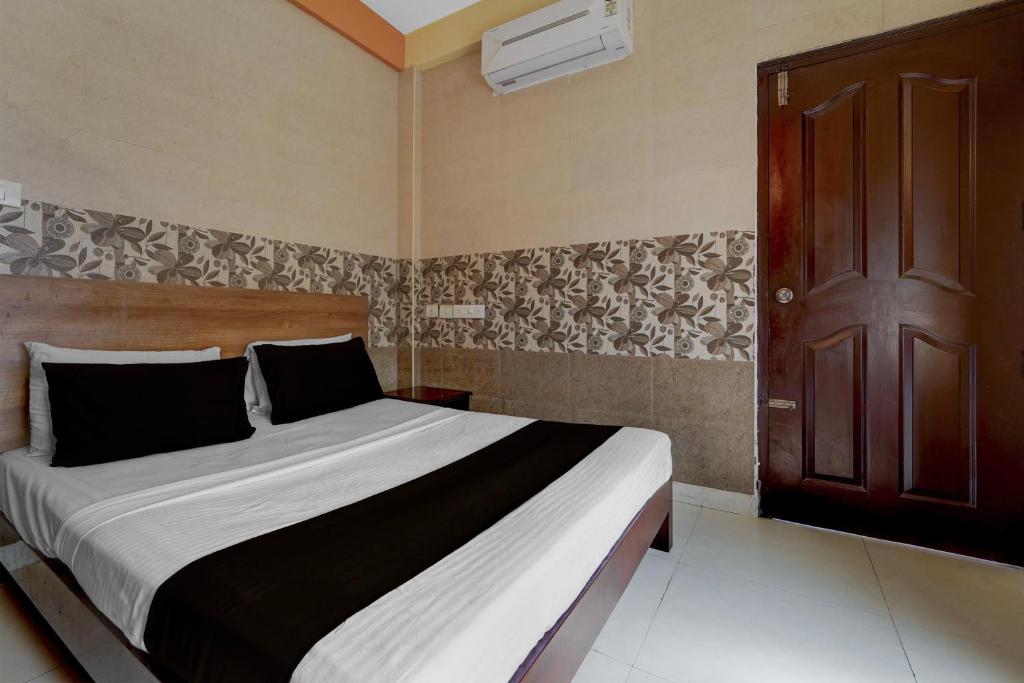 a bedroom with a large bed and a brown door at Collection O KSRTC Bus Station Kottayam Formerly Hotel O Day Springs in Kottayam