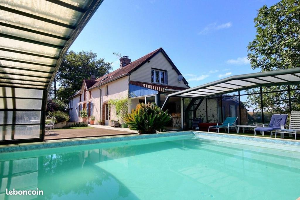 une piscine devant une maison dans l'établissement Le Clos Fleuri, à Pontiacq-Viellepinte