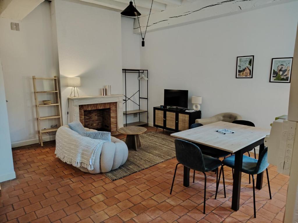 - un salon avec une table, un canapé et une cheminée dans l'établissement Authentique Bouquet, au Mans