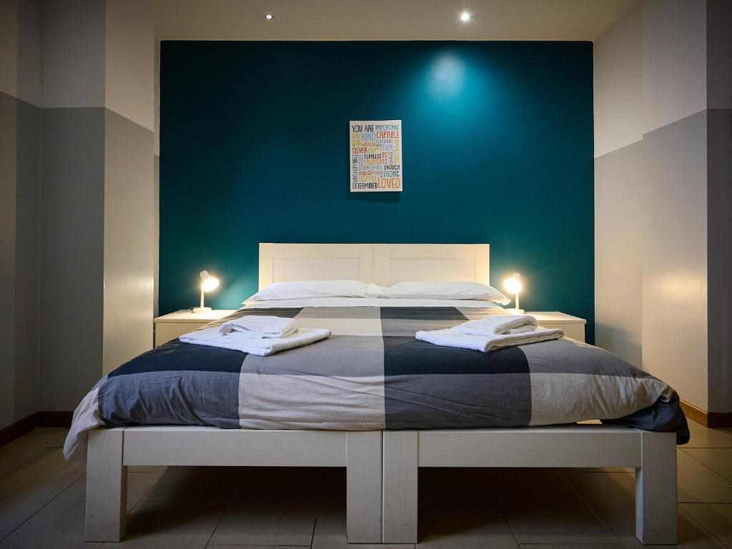 a bedroom with a large bed with a blue wall at L'Archetto in Cremona