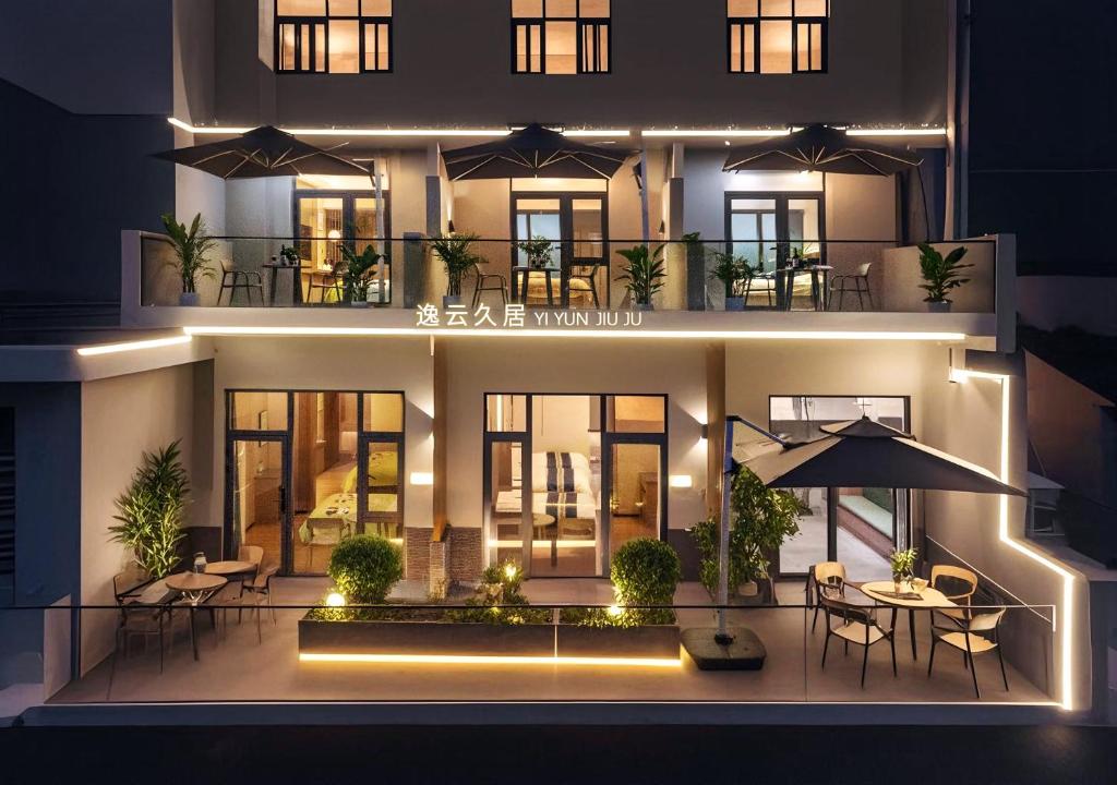 - Vistas nocturnas a un edificio con mesas y sillas en Yiyun Residence, en Hanqiyu