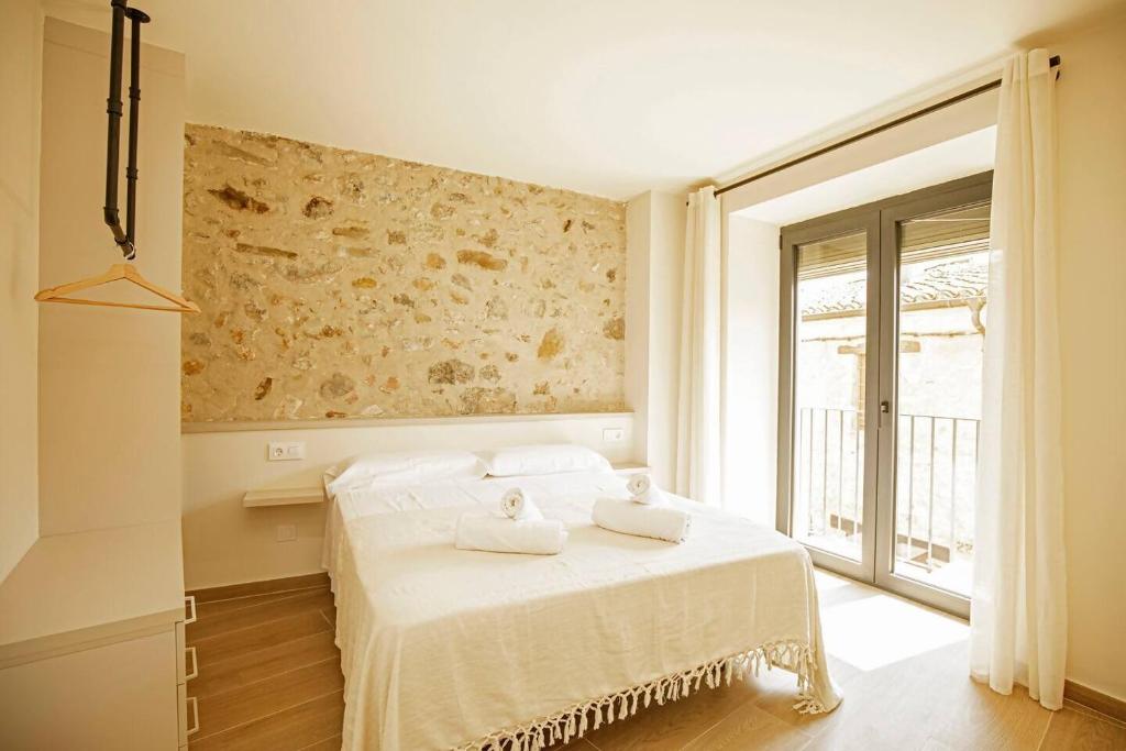 贝萨卢Apartamento en el Pont Vell的卧室里有一张床，床上放着两条毛巾。