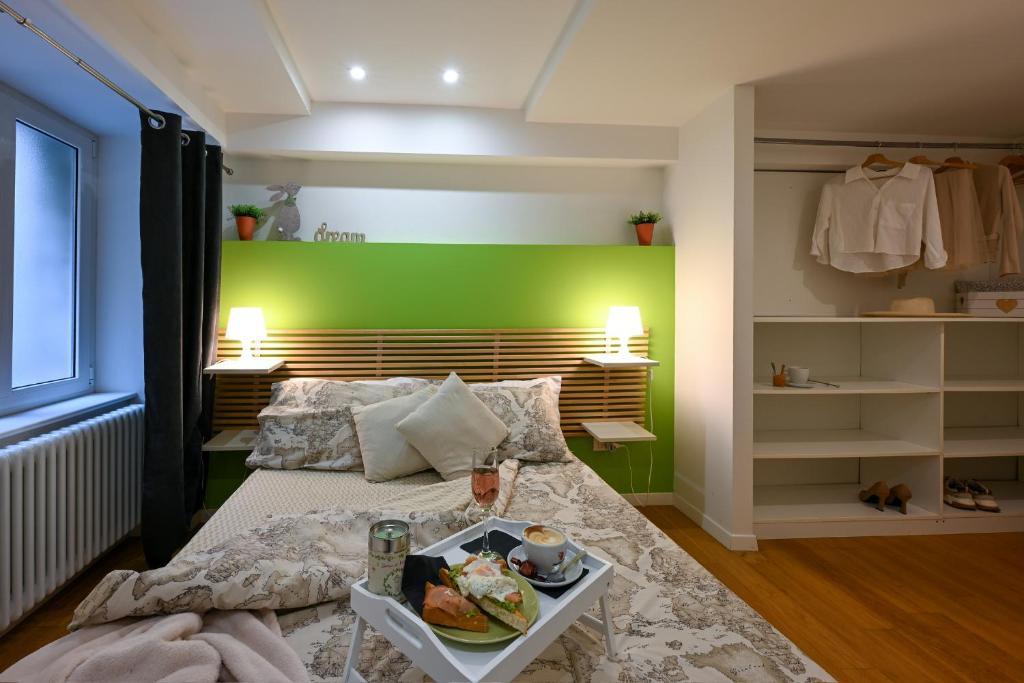 a bedroom with a bed and a green wall at La Tana di Alice in Muggia