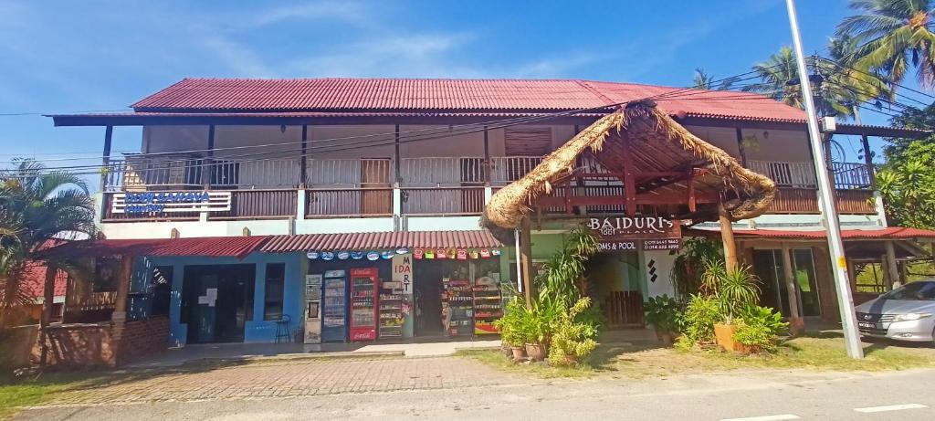 a building with a red roof on a street at Baiduri's Place in Pantai Cenang