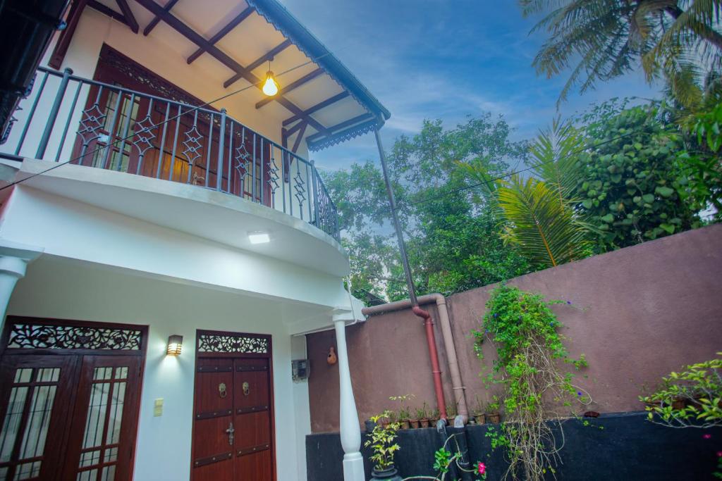 哈巴拉杜瓦Villa Aliya的带阳台和门的白色房屋