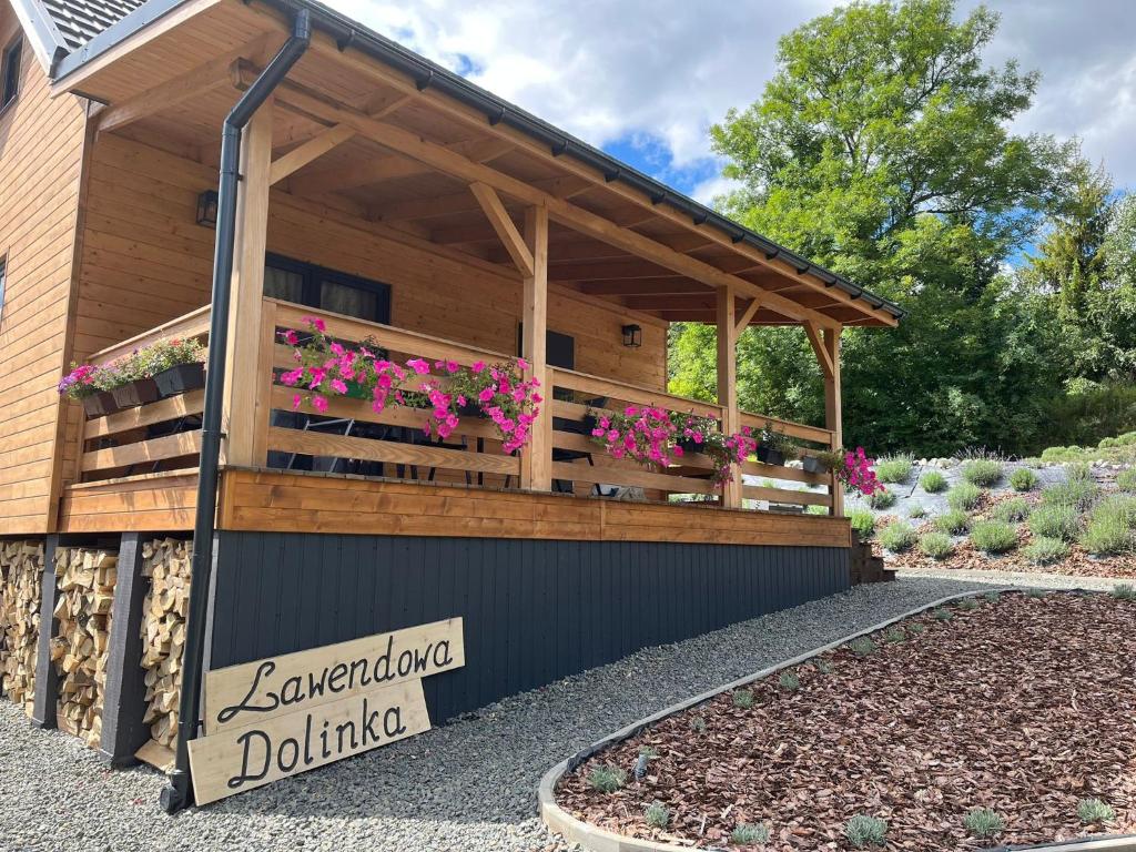 a wooden building with flowers in a garden at Domek Beskid Niski in Chyrowa