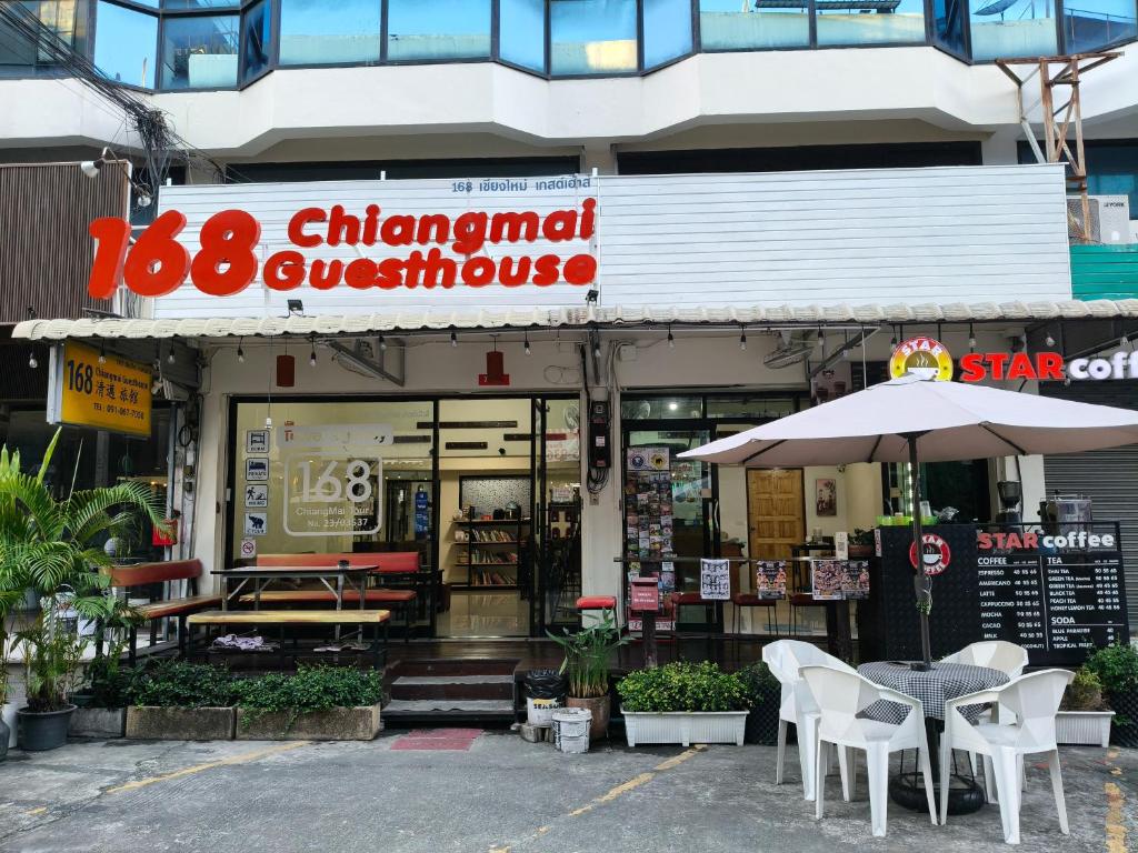 a restaurant with a table and chairs and an umbrella at 168 Chiangmai Guesthouse in Chiang Mai