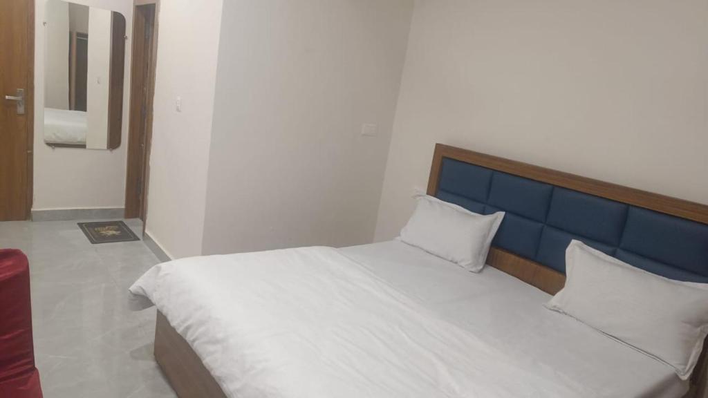 een slaapkamer met een groot bed met een blauw hoofdeinde bij Hotel Ashoka in Karnāl
