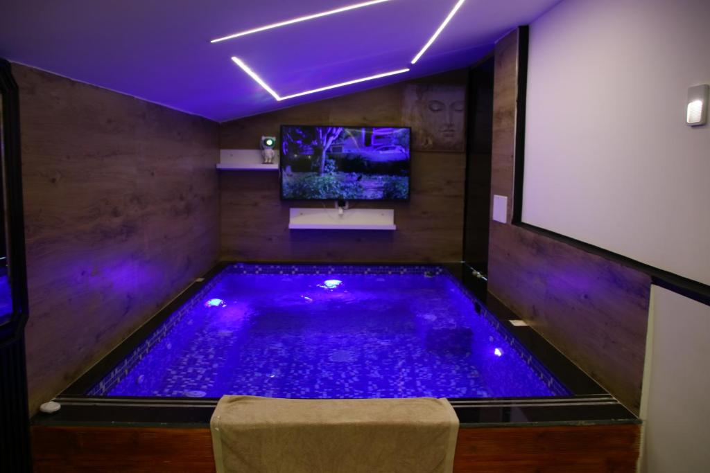 a lap pool in a room with purple lighting at Villa Jaupaj in Vlorë