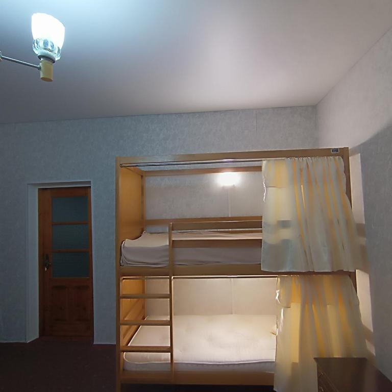 2 łóżka piętrowe w pokoju z lampką w obiekcie Mary&George w mieście Crăsnăşeni