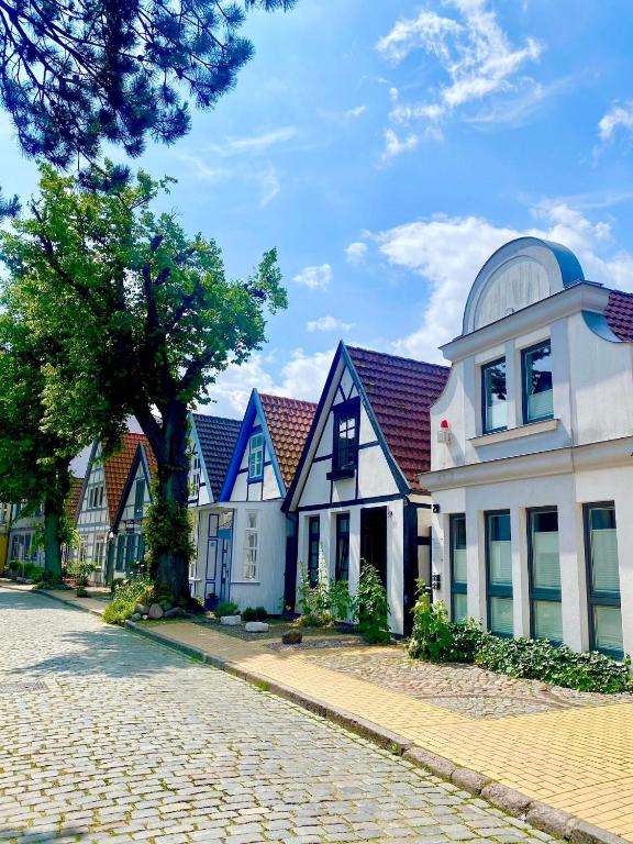 a row of houses on a cobblestone street at MAISON ART Appartements - Objekt 94080 in Warnemünde