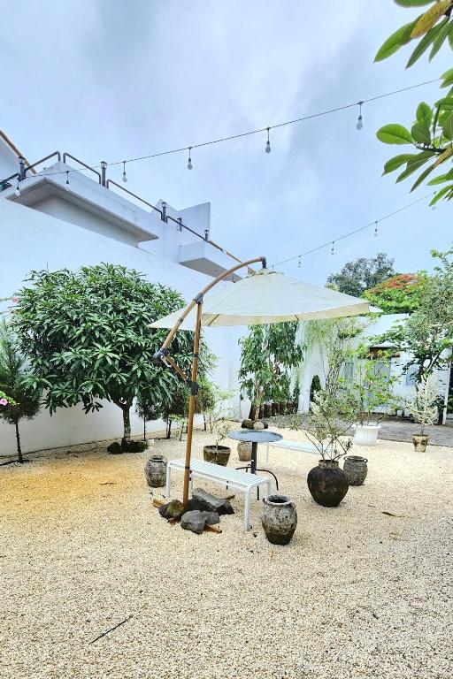a picnic table and an umbrella in front of a building at Floraison Living Villa Yogyakarta in Ngaglik
