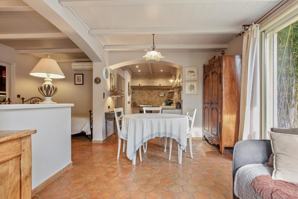 L'Arbousier في Laouque: غرفة طعام مع طاولة ومطبخ