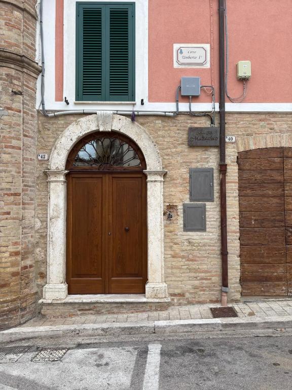 a building with a wooden door on a street at BB Maltagliati in Torano Nuovo