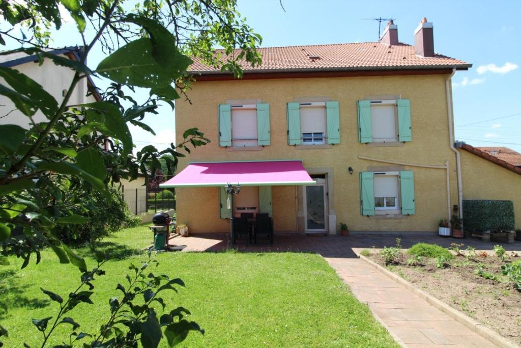 a house with a pink awning in front of it at Gîte Chez Reine à ÉtivalClairefontaine Vosges Cal in Étival-Clairefontaine