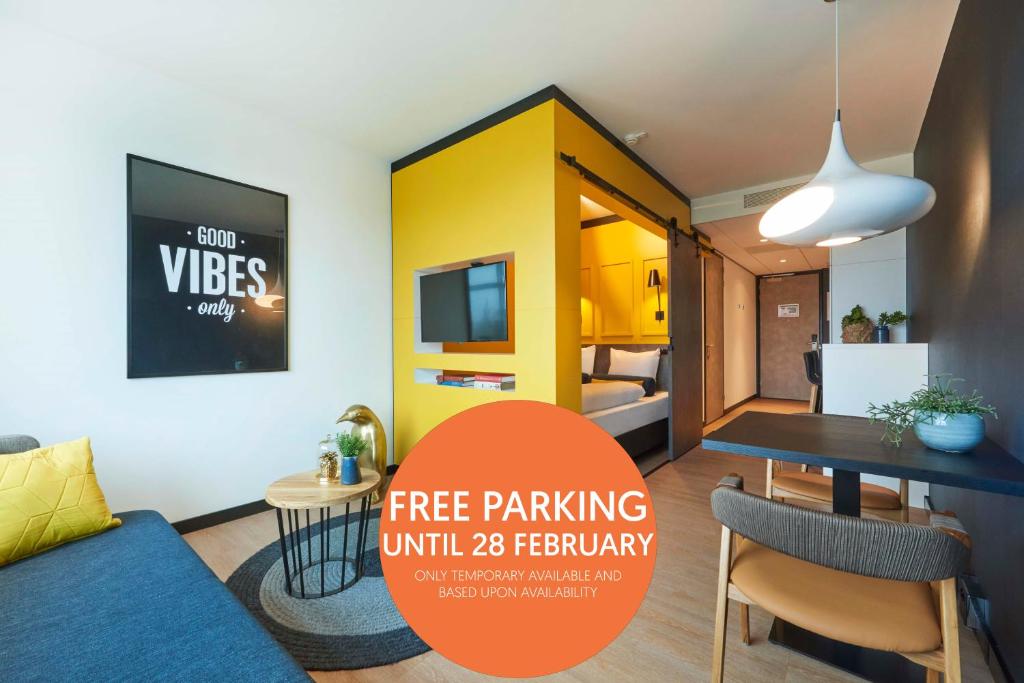 a living room with a couch and a dining room at Cityden Zuidas in Amstelveen