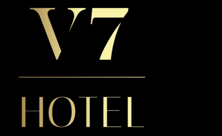 Un logotipo de hotel amarillo sobre un fondo negro en Hotel V7, en Milán