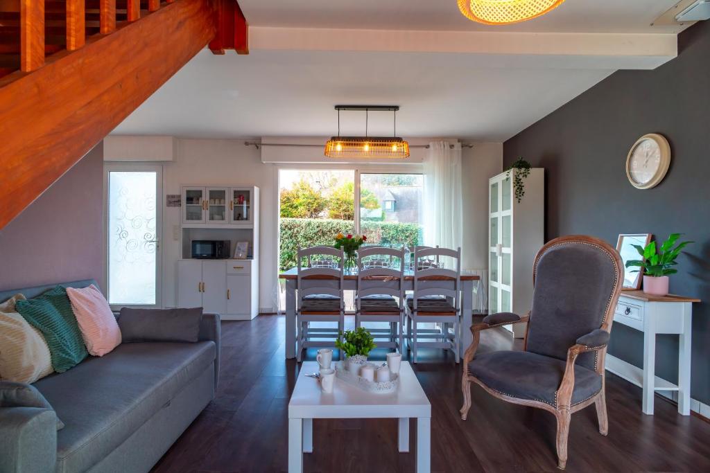 een woonkamer met een bank en een tafel bij Ty Kordenn - Proche Plage in Sarzeau