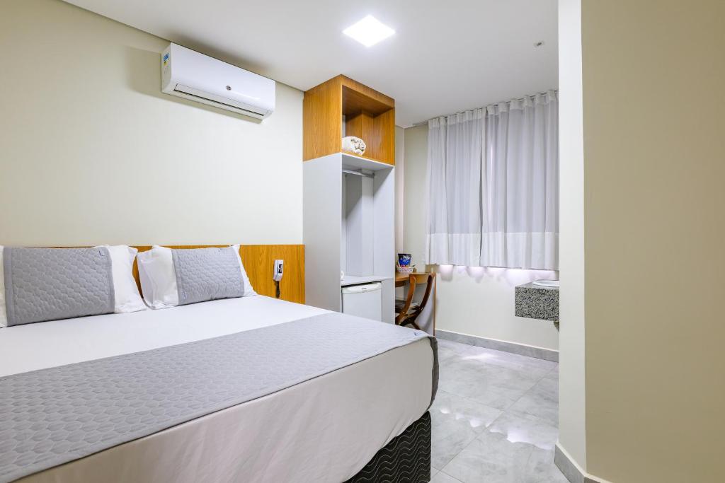 a bedroom with a bed and a bathroom at OYO Hotel Brisa Tropical, Brasília in Brasília
