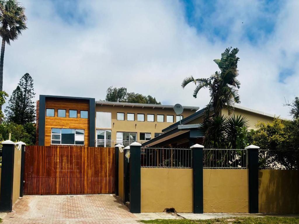 Starlight Inn Boutique Hotel في Humewood: منزل به بوابة خشبية وسياج