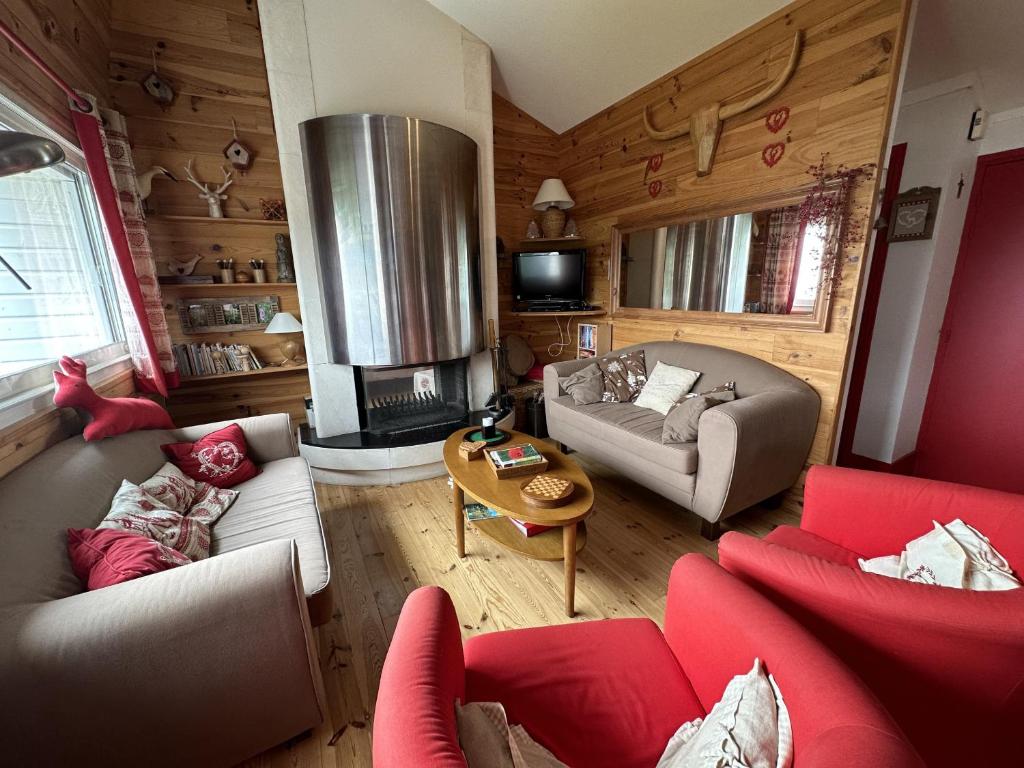 ein Wohnzimmer mit roten Möbeln und einem Kamin in der Unterkunft Appartement esprit montagne in Le Lioran