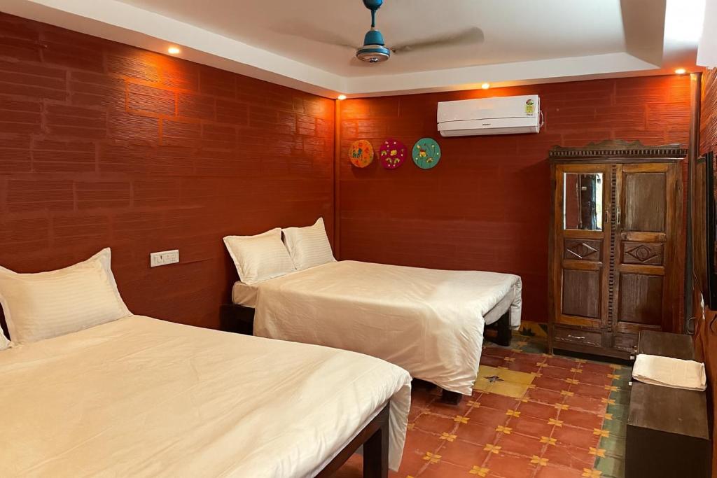 蒂鲁奇奇拉帕利Srirangam Heritage Farmhouse - Perfect Spot for Parties & Events的红色墙壁客房的两张床
