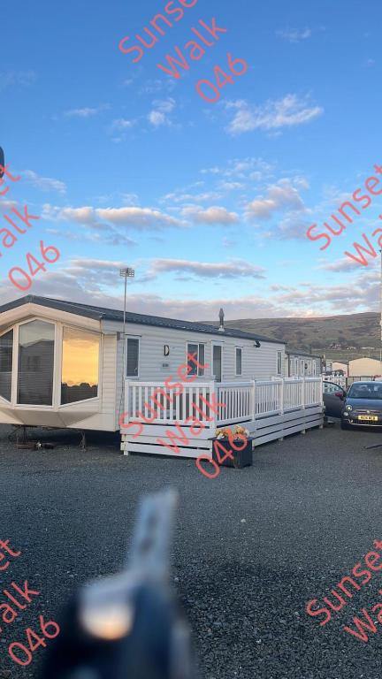 a white trailer is parked in a parking lot at Sunset Walk 046 in Barmouth