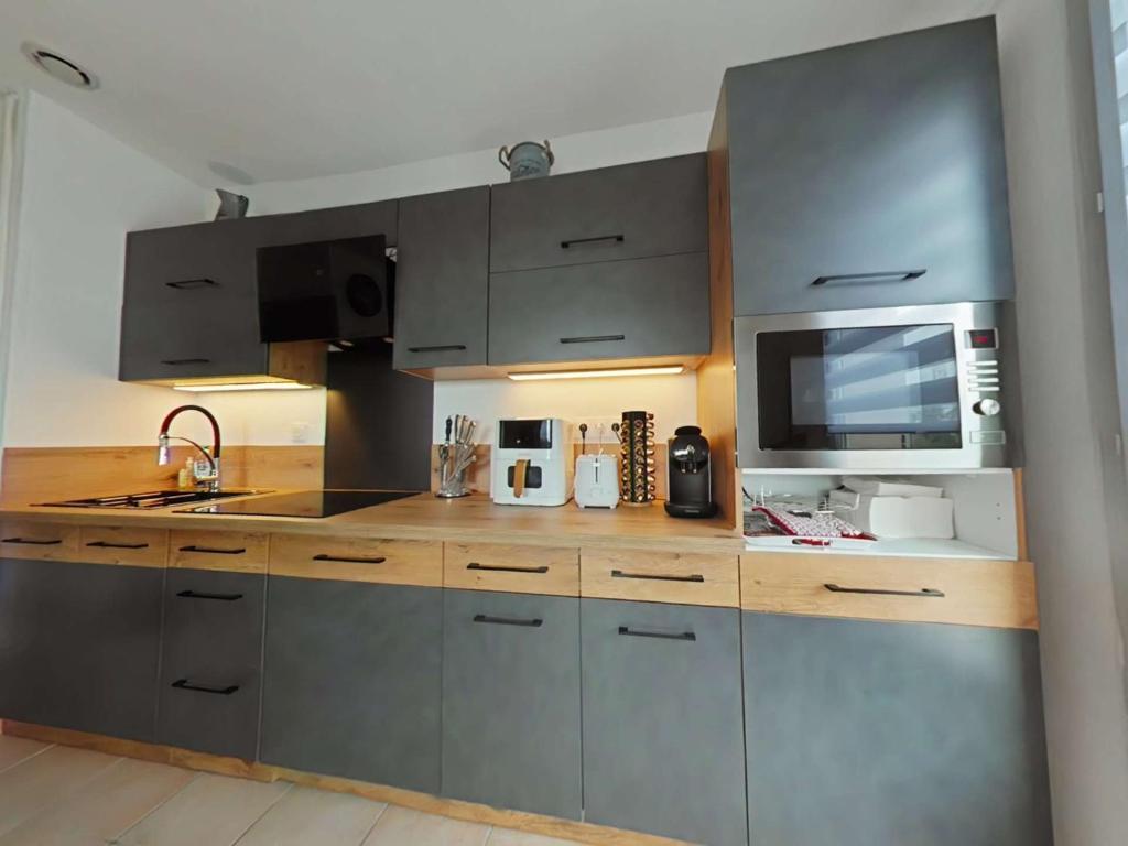 勒卡特海滩Mais 2 pièces 4 couchages PORT LEUCATE NATURISME PL040-040的厨房配有不锈钢橱柜和微波炉