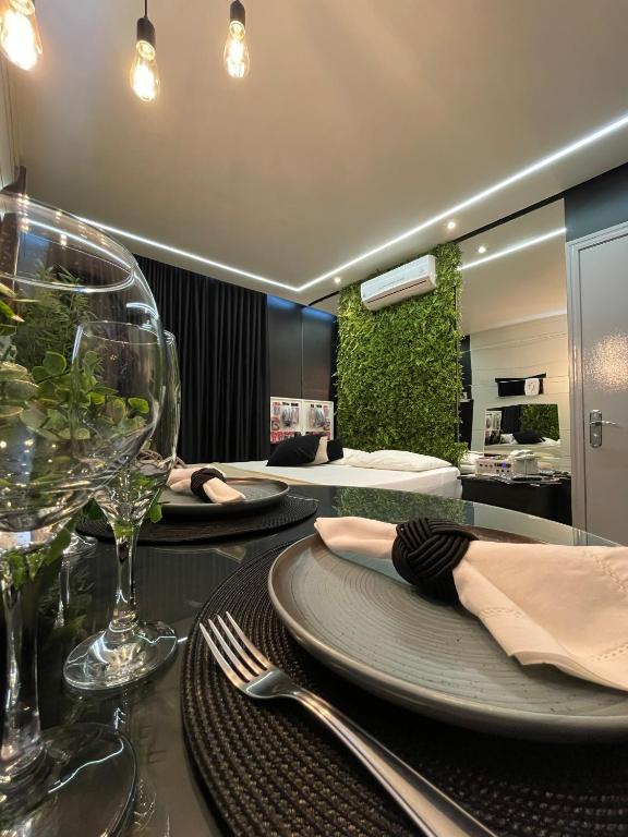 a dining room with two tables with plates and wine glasses at Hotel Motel Paradiso - Soledade-RS in Soledade