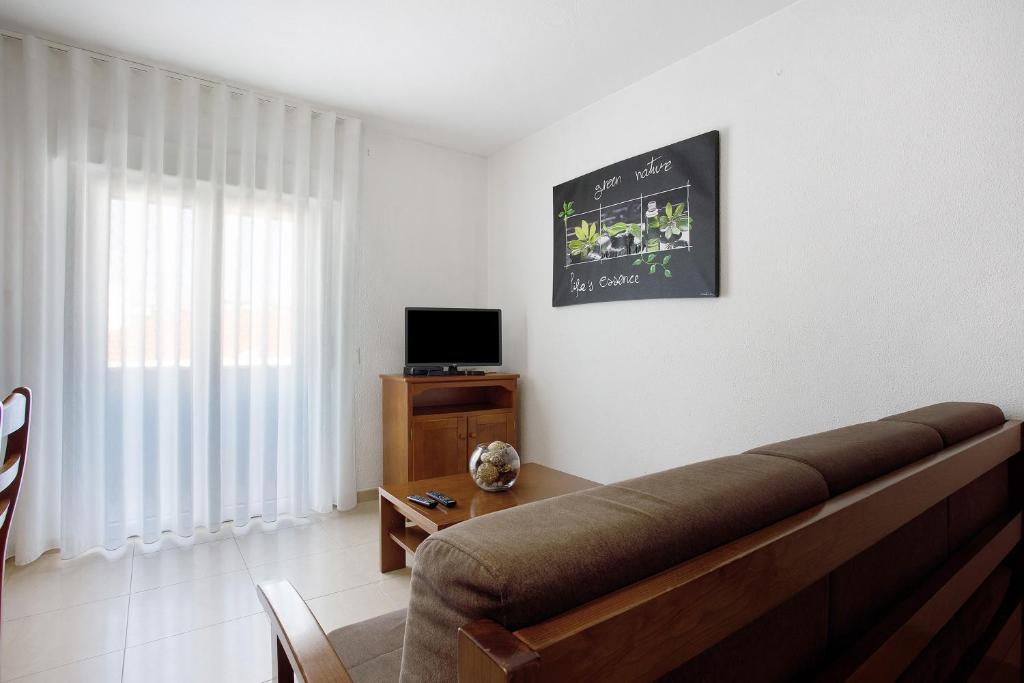 ein Wohnzimmer mit Sofa und Fernseher in der Unterkunft Campo Mar - T1 vista praia in São Martinho do Porto