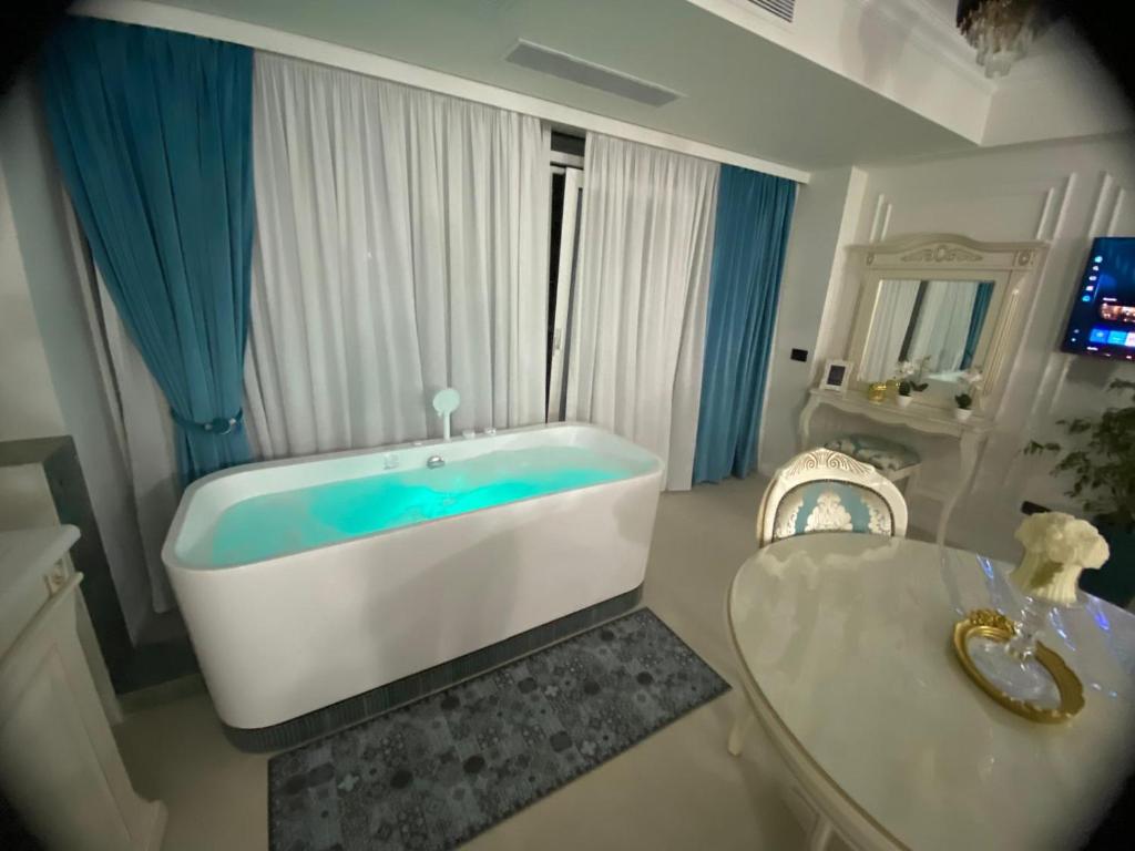 a bathroom with a tub and a table in it at Luxury by White TitanicBreeze in Mamaia Nord