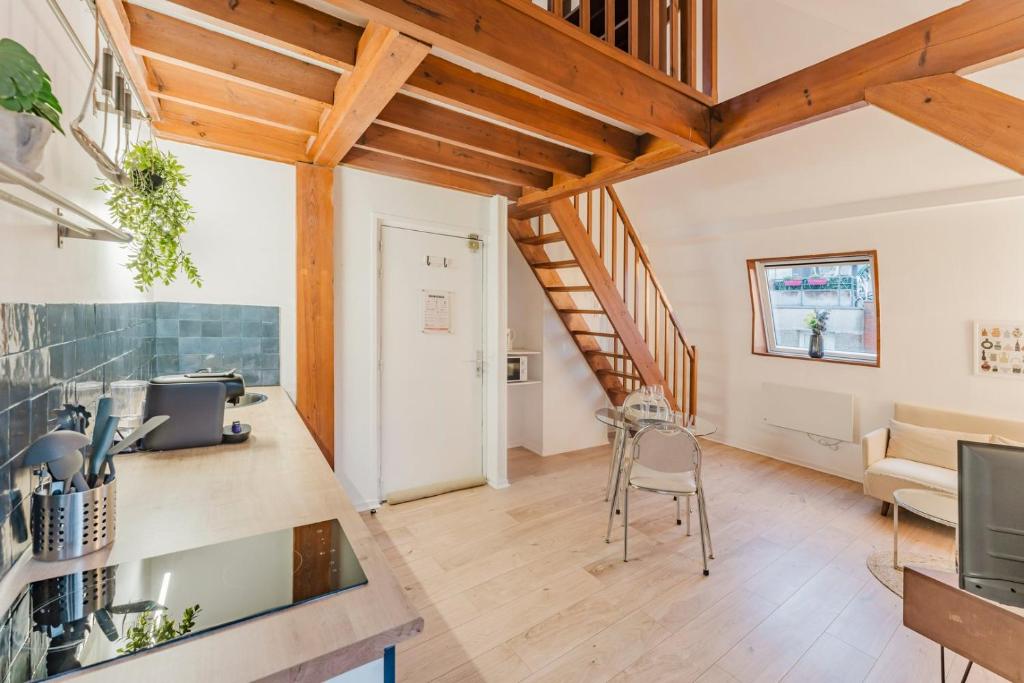 ein offenes Wohnzimmer mit Holzdecken und einer Treppe in der Unterkunft Appartement 1 chambre mezzanine centre de Roubaix in Roubaix