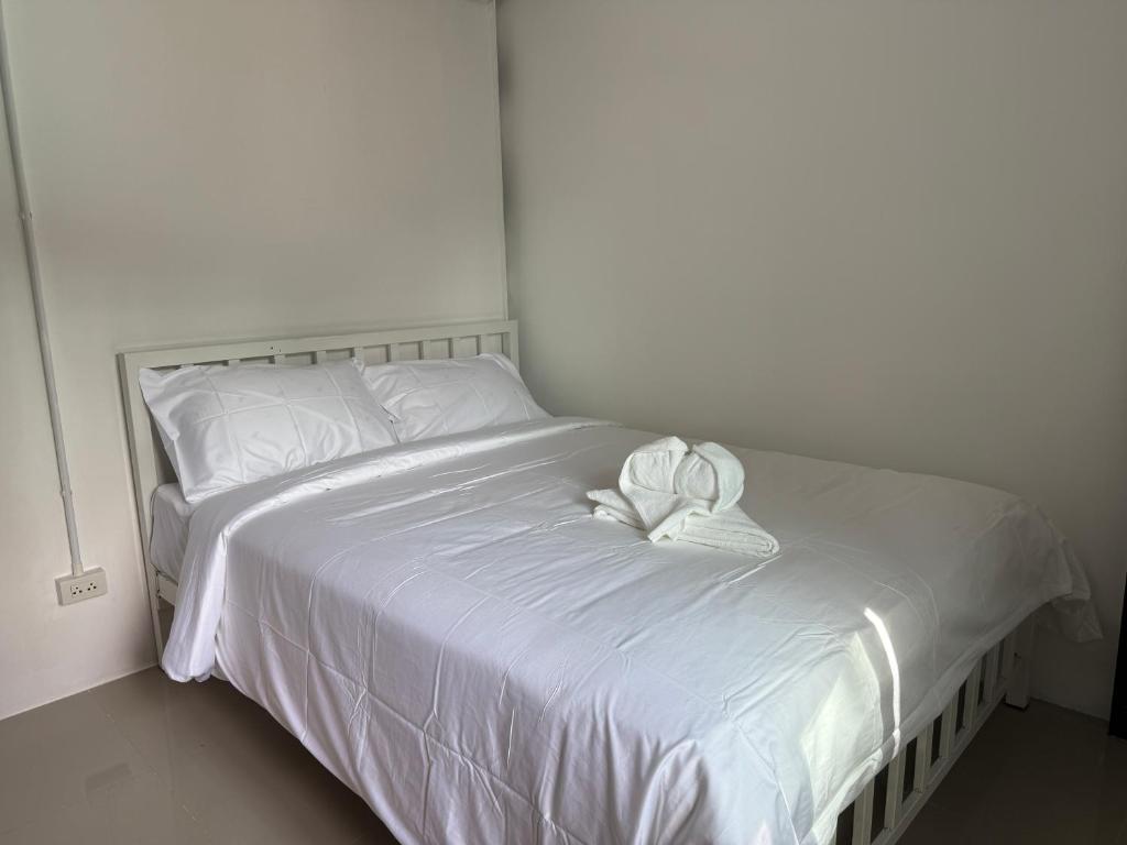 ein weißes Bett mit zwei weißen Handtüchern darauf in der Unterkunft Flow Stay Koh Samet I10 流宿沙美島 雙人房 Double room, private bathroom, 2-5mins walk distance to pier and everywhere in Ko Samed