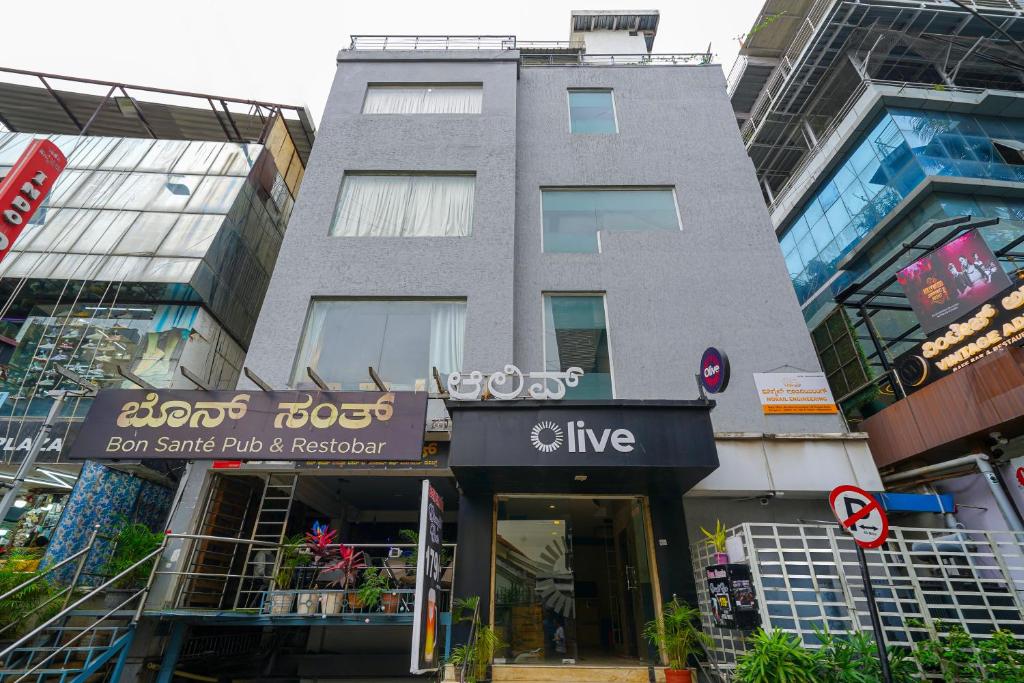 Un edificio alto con una tienda en funcionamiento en una ciudad. en Olive Zip Rest House Road by Embassy Group, en Bangalore